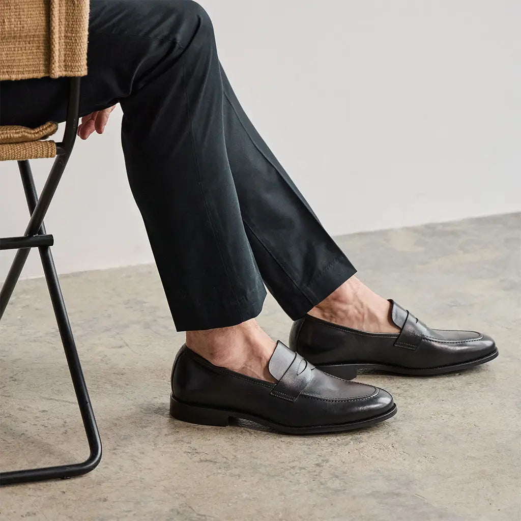 Man wearing dark penny loafers with slacks